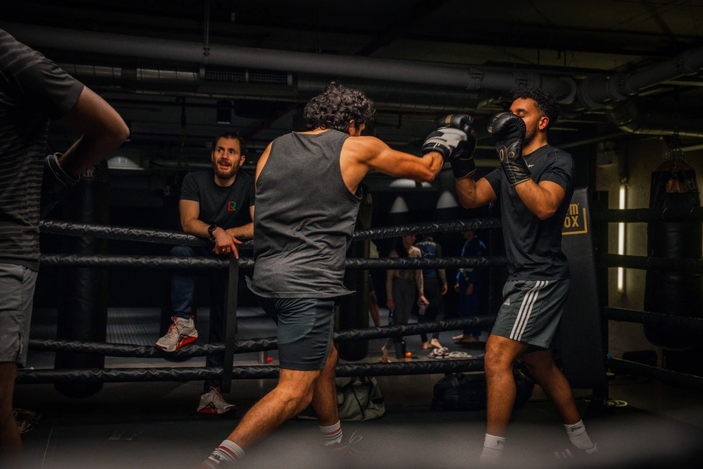 Two men sparring in a boxing training session